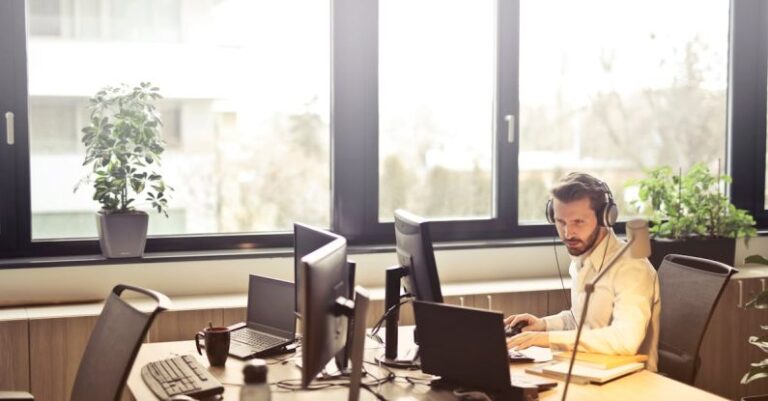 Customer Support - Man With Headphones Facing Computer Monitor