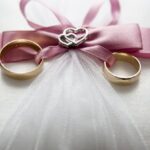 Engagement - Selective Focus Photography of Silver-colored Engagement Ring Set With Pink Bow Accent on Throw Pillow