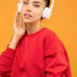 PPC Trends - Woman in Red Sweatshirt and Blue Jeans Wearing White Headphones