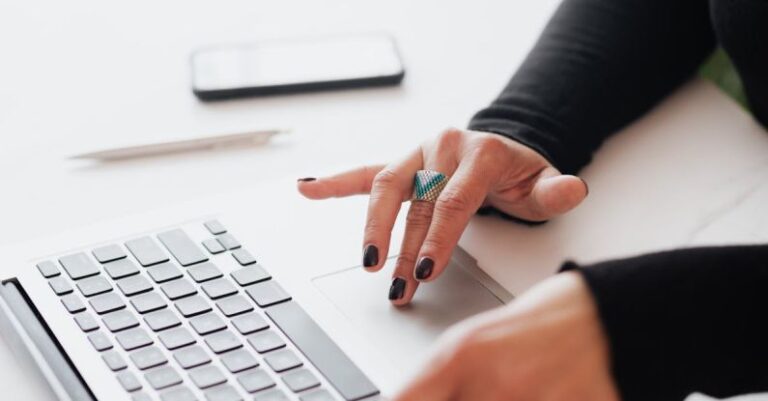 Local SEO - Crop female using touchpad on laptop in office