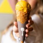 Affiliate Offers - A woman holding up an ice cream cone with a yellow and orange swirl