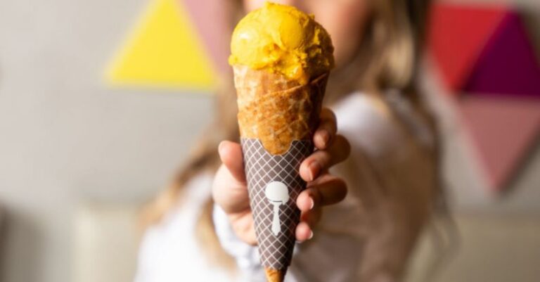 Affiliate Offers - A woman holding up an ice cream cone with a yellow and orange swirl