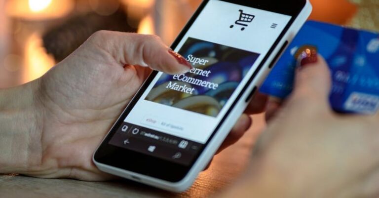 E-Commerce Websites - Person Using Black And White Smartphone and Holding Blue Card